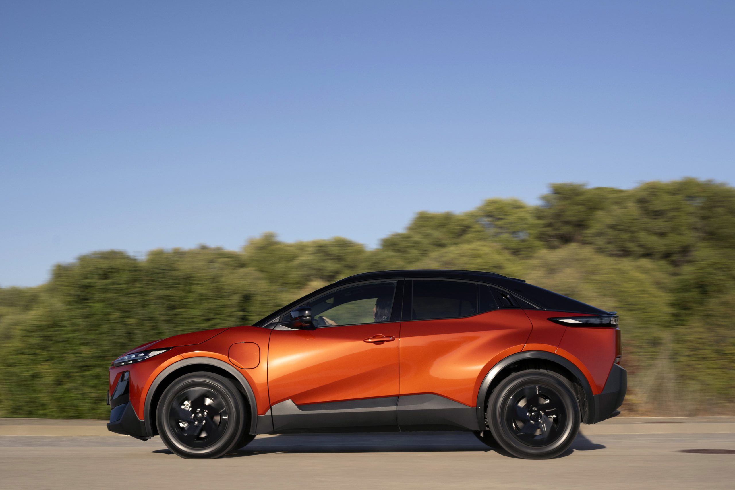 zijaanzicht van de Subaru Uncharted in de kleur flare orange statisch op een weg buiten de stad